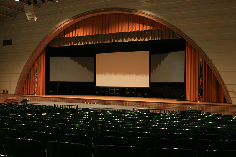 the inside of the Octorara Area High School auditorium featuring complex curved walls and an arch framing the stage