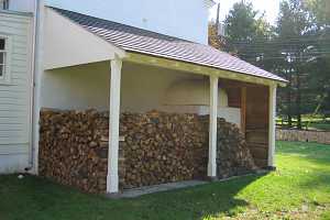 Firewood stacked beside the outside of a beehive bake oven