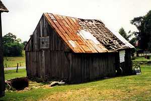 a dilapidated shed with a broken roof and windows