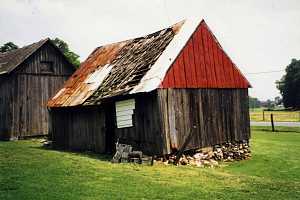 a dilapidated shed with a rusted and destroyed roof