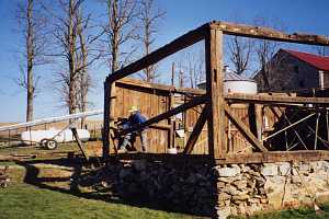 worker disassembling an old shed