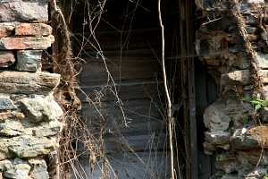 a covered door in the old stone wall of a barn