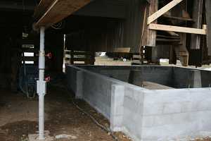 barn suspended above new concrete cinderblock foundation