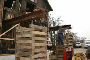 barn being raised by workers on top of steel beams