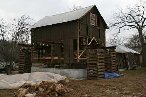 barn suspended above new concrete foundation