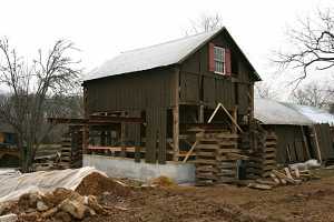 barn being lowered onto new concrete foundation