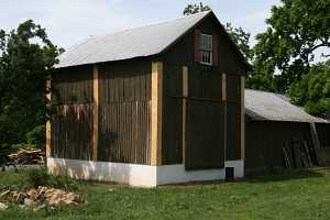 barn exterior being reassembled after being secured to new foundation