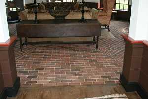 a sitting area with a red brick floor