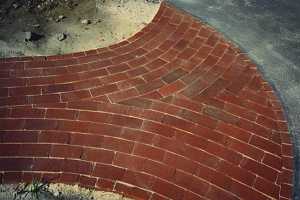 a circle parttern brick patio leading to a driveway