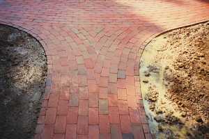 a rounded brick walkway converging on a brick sidewalk