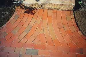 a rounded brick pattern leading to a stone step