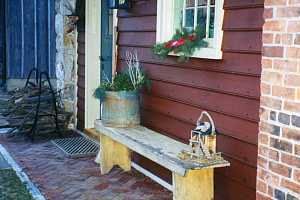 a brick patio with a bench and firewood stacked on it