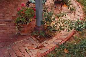 a brick patio with planters and outdoor furniture