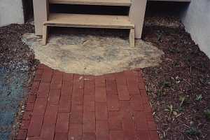 brick walkway ending at a stone landing and wooden steps