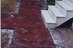 a brick walkway leading to a staircase and cellar