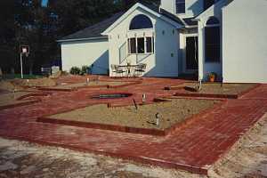 a newly installed decorative brick patio with 4 visible planting areas included