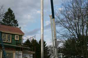 A chimney duct suspended by a crane in preparation for installation