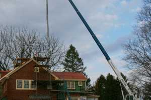 A chimney duct suspended by a crane in preparation for installation