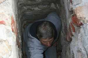 A man repairing an old chimney flue