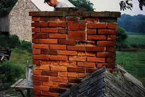 A brick chimney with some damage