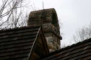 A decorative stone chimney with arch