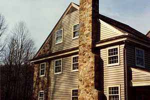 A stone chimney running up the side of a home