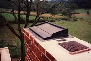 Top of a brick chimney looking at the flue damper