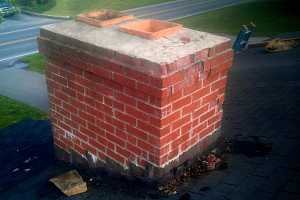 A cracked brick chimney beginning to break down