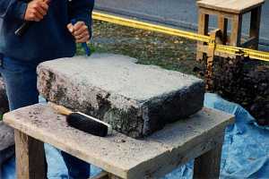 A large stone being formed by a chisel and hammer