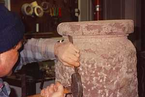 A stonemason beginning to form an outdoor sundial pillar