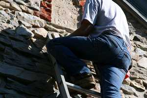 Stonemason examining an old date stone in need of refurbishment