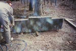 cement base standing on three wood planks in the woods