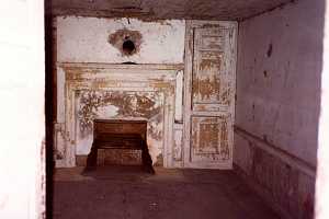 an old fireplace area with chipping white paint and wall pieces - before