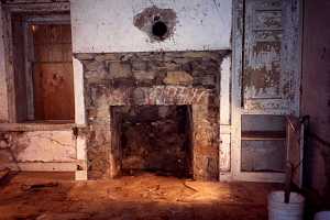 an old stone and brick fireplace with chipping white paint and wall pieces - before