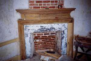 an old fireplace made of damaged brick and stone - before