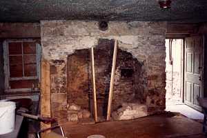 an old stone fireplace being opened up through removal of stone