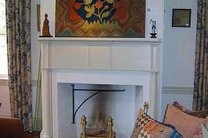 a fireplace area with a decorative painting above it