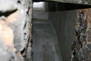 looking up a freshly sealed stone fireplace chimney