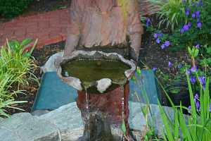 a small boy water fountain in a fish pond