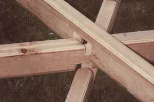 demonstrating how three pieces of a wooden gazebo come together