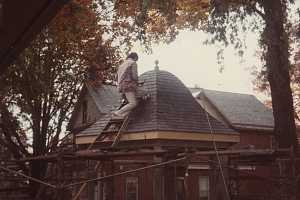 a man putting the roof on a gazebo