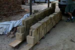 dozens of custom bricks stacked on two long planks