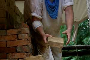 a man in white stacking bricks