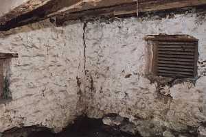 The inside of an old stone spring house in poor shape