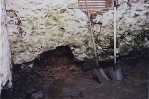 Stones missing from the wall of an old spring house