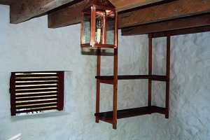 A lantern and shelving in a restored spring house