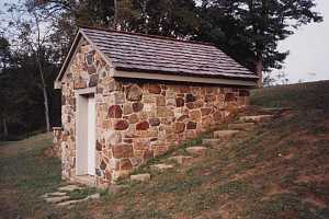 A restored stone spring house built into a hill