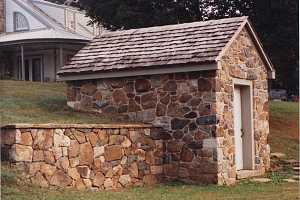 A restored stone spring house built into a hill