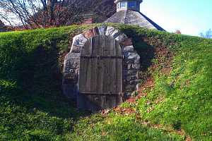 An underground spring house with an arched door