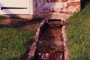 Water flowing out of a stone spring house built in 1989